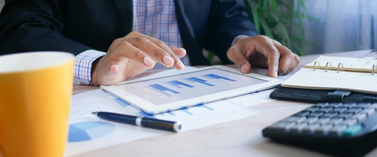 Tablet mit Kalkulation auf Schreibtisch